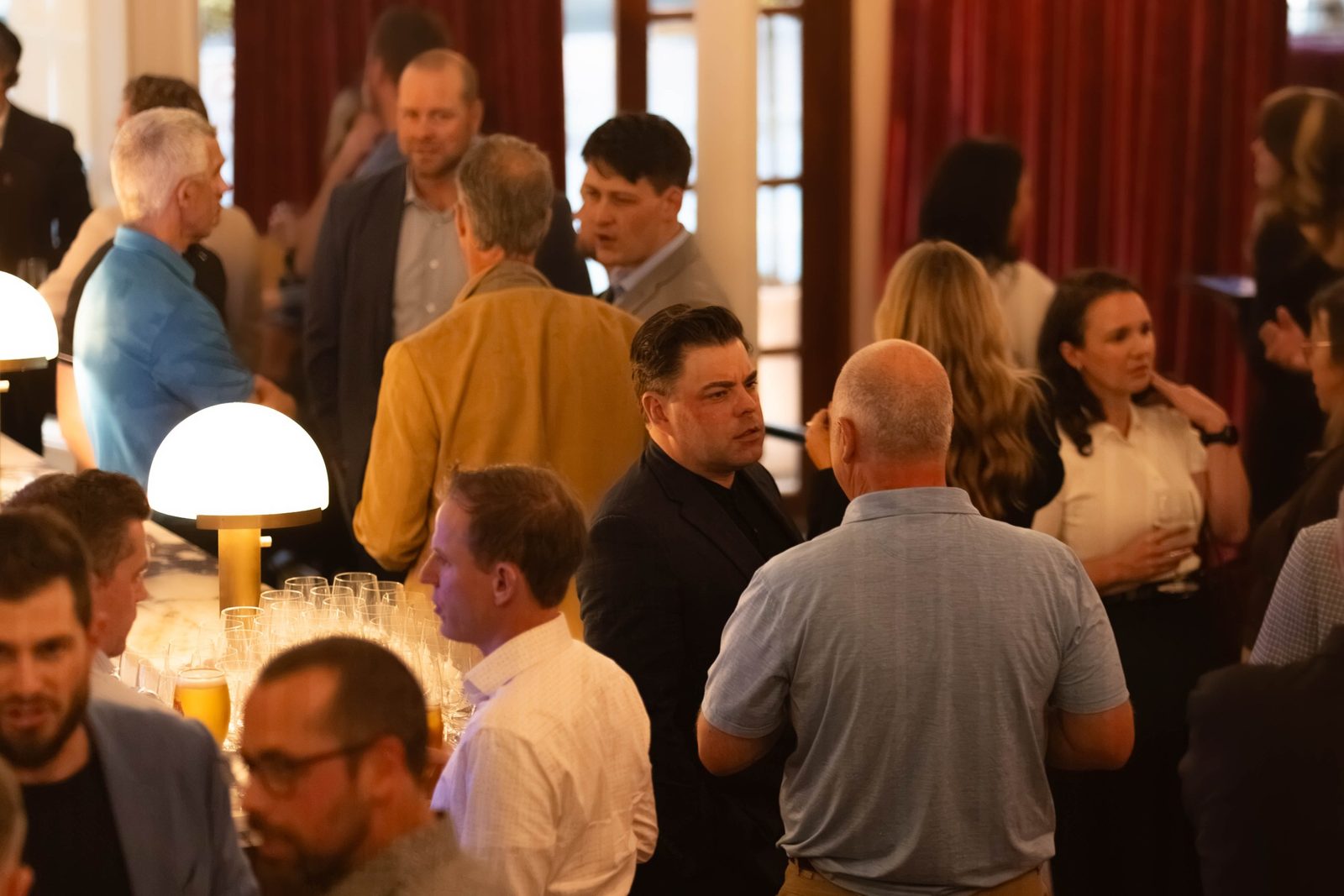 Members in conversation around the bar at a Commercial Group evening in Halifax