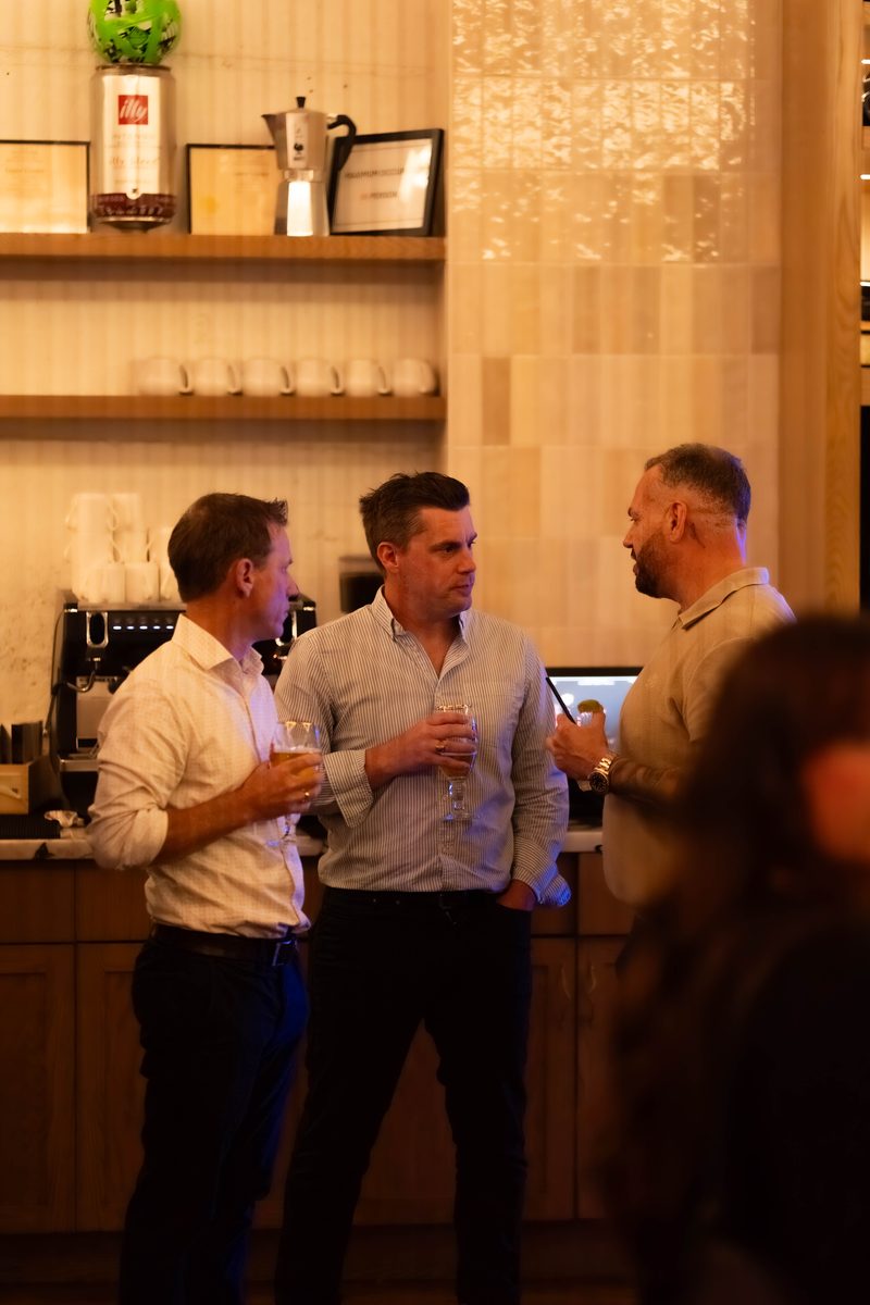 Three members talking at the bar