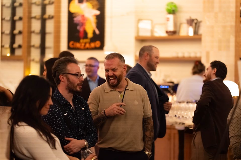 A group laughing together at the bar later in the evening
